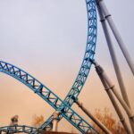 Vertical steel roller coaster track with sunset sky in Rust, Germany. Captivating amusement park structure.