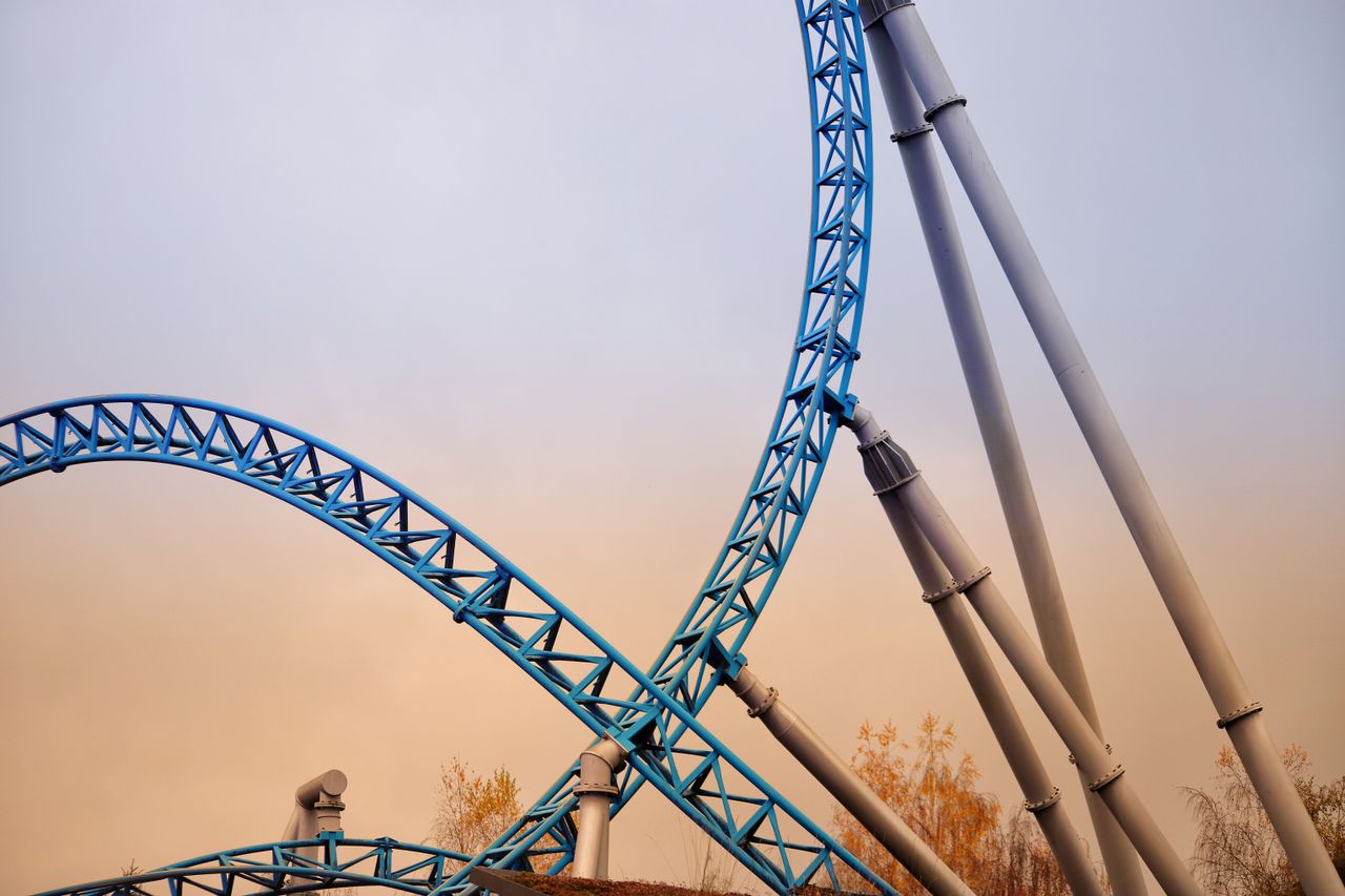 Vertical steel roller coaster track with sunset sky in Rust, Germany. Captivating amusement park structure.