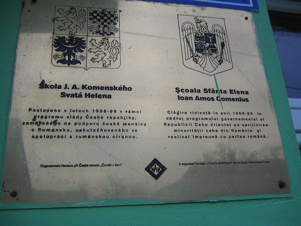 Dvojjazyčná deska na škole ve Svaté Heleně s nápisem Škola J. A. Komenského a Școala Sfânta Elena