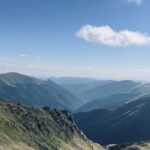 Široké travnaté hřebeny klesající do hlubokých zalesněných údolí