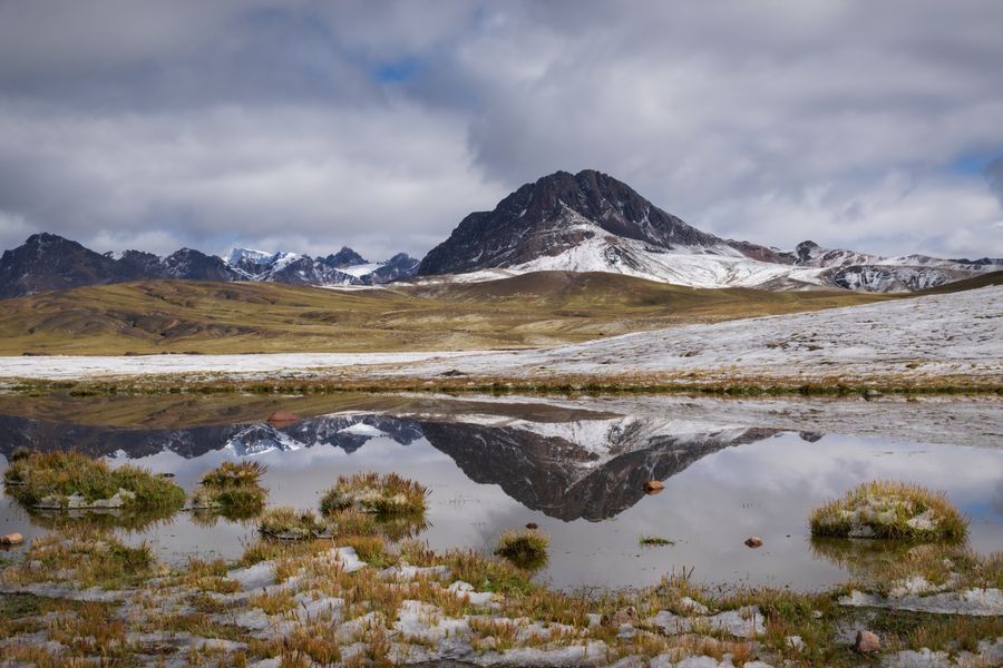 Andské vrcholy zrcadlící se ve vodě poblíž Cuzca v Peru