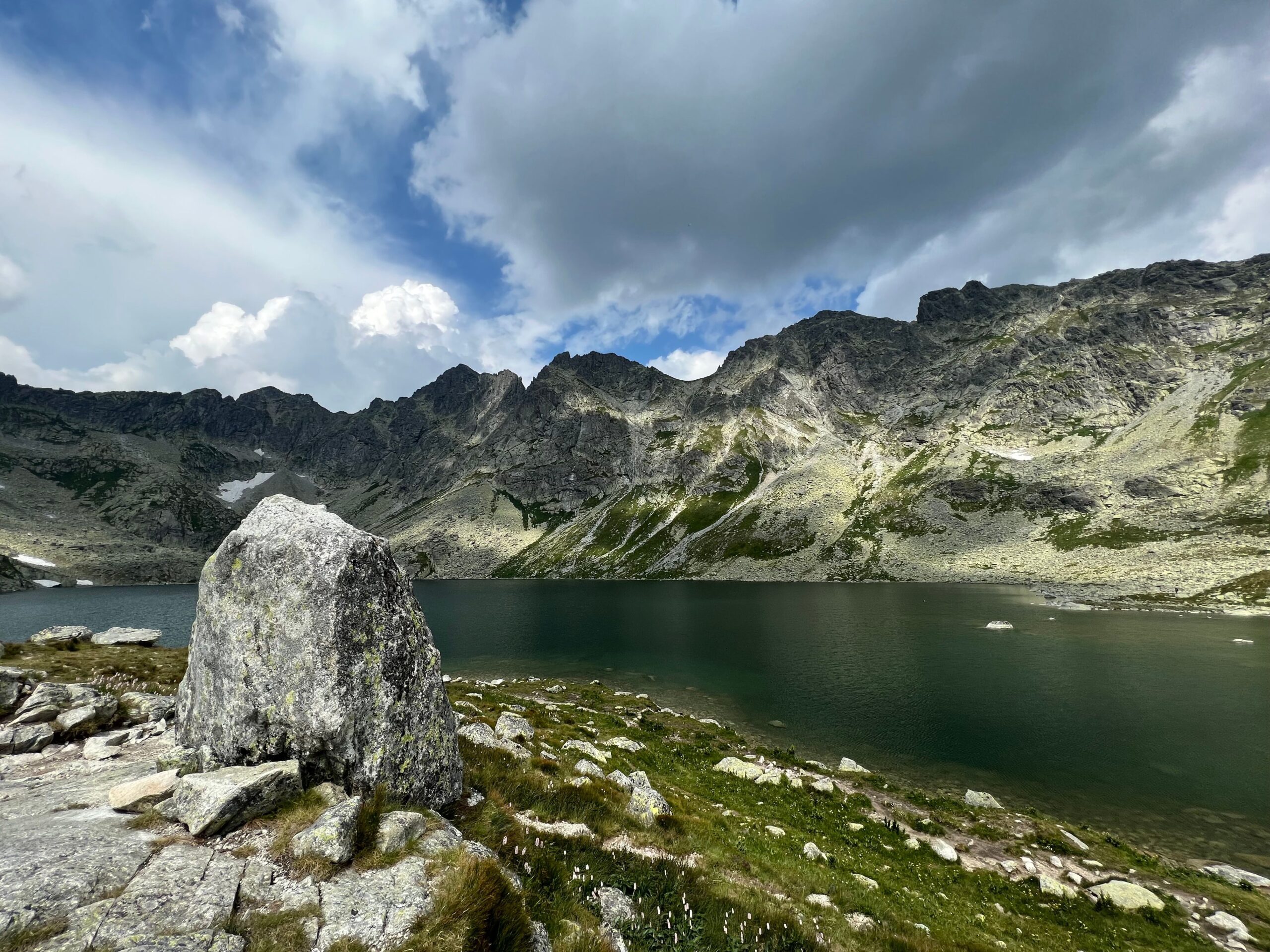 Mountain lake in a rocky basin in the High Tatras of Slovakia under a cloudy sky