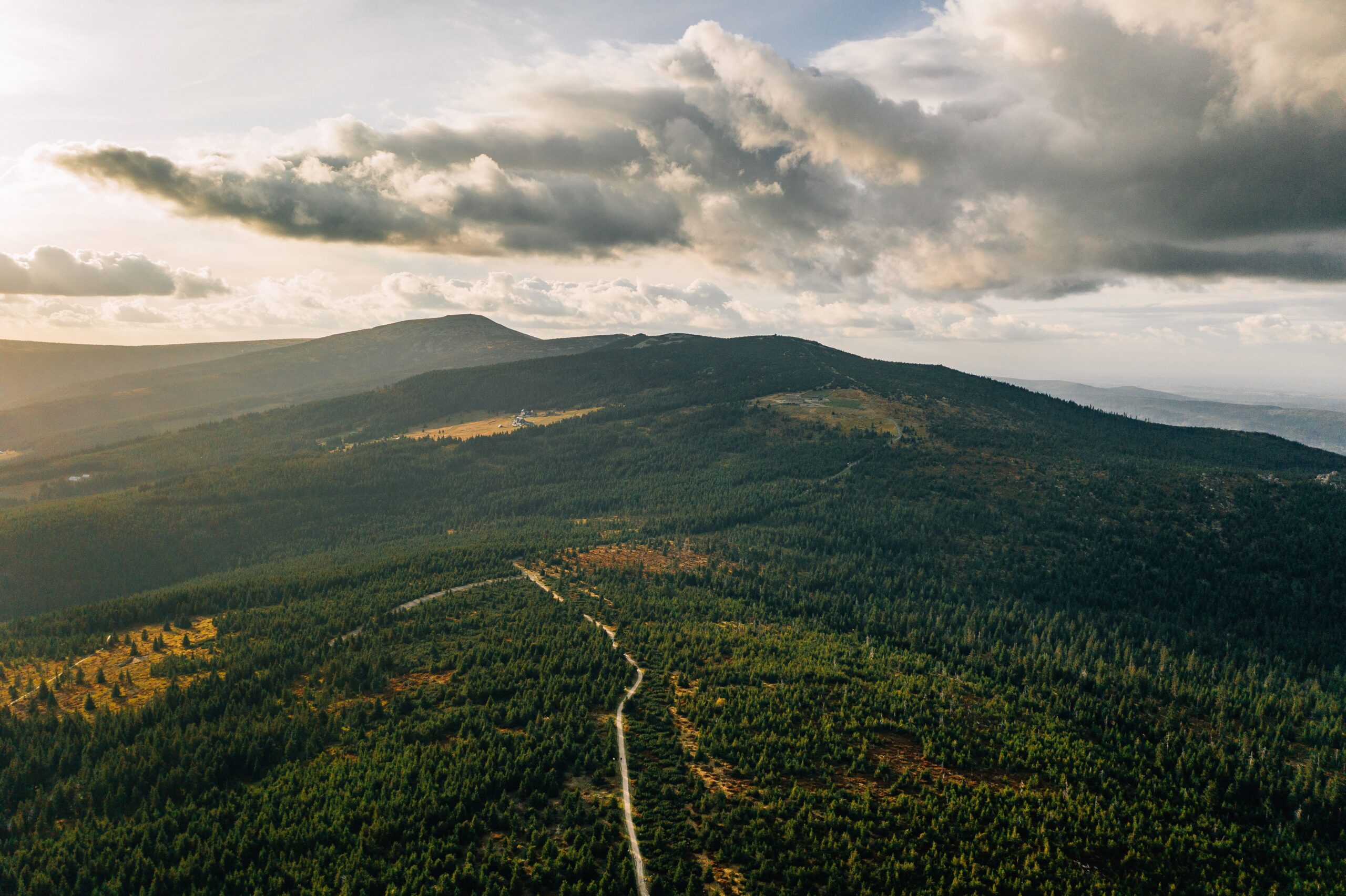 Forested Beskydy ridges under a dramatic sky, seen from above