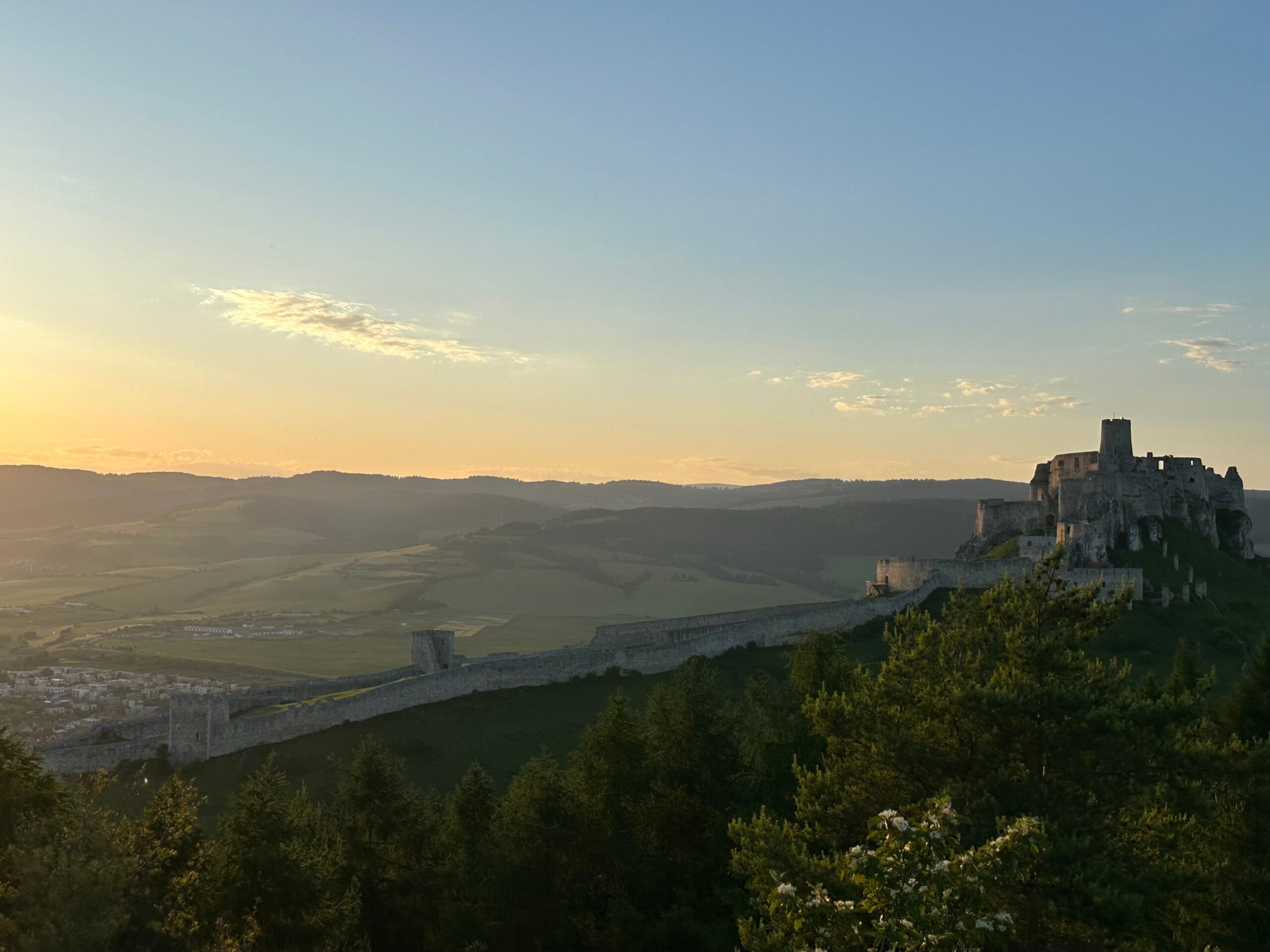 Spišský hrad castle on a hill above the countryside at sunset