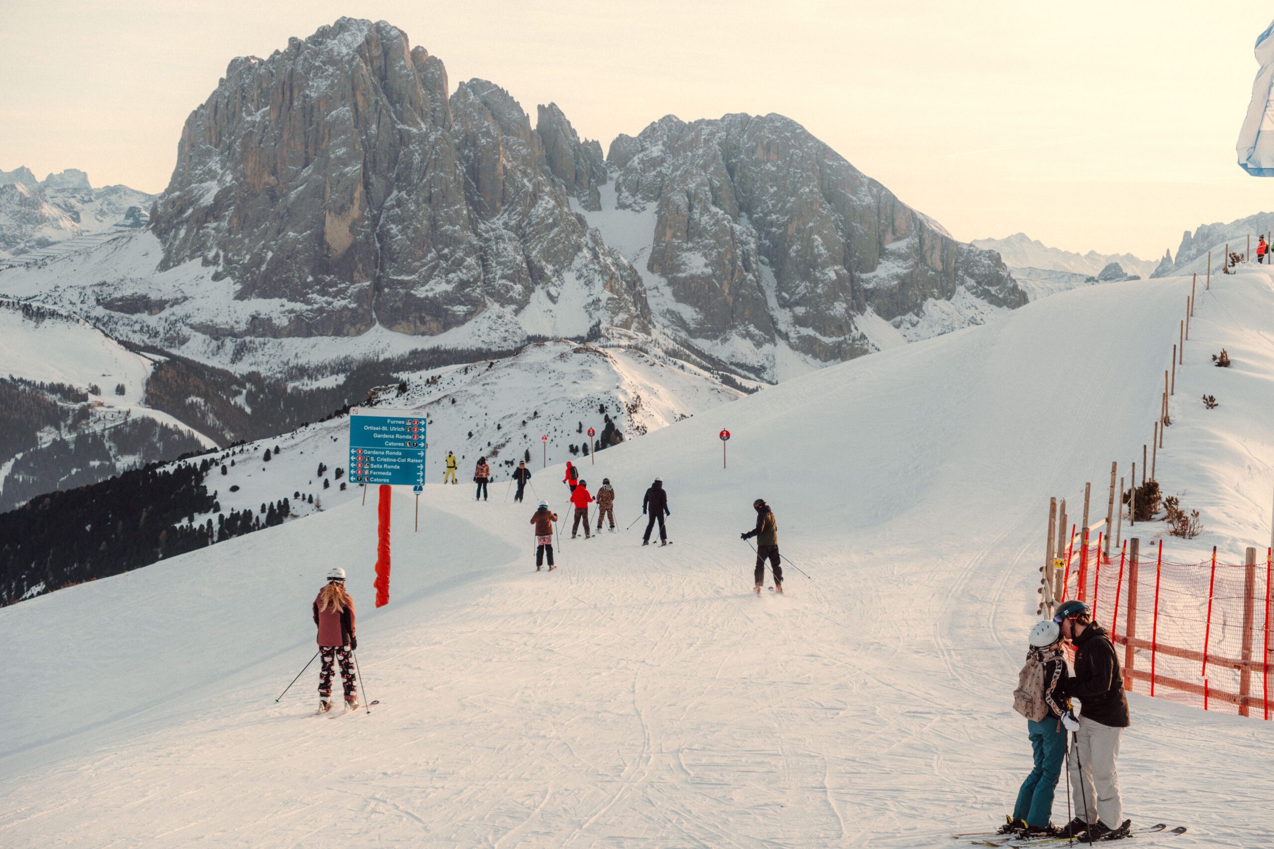 Skifahrer auf einer Piste in den italienischen Dolomiten unter blauem Himmel