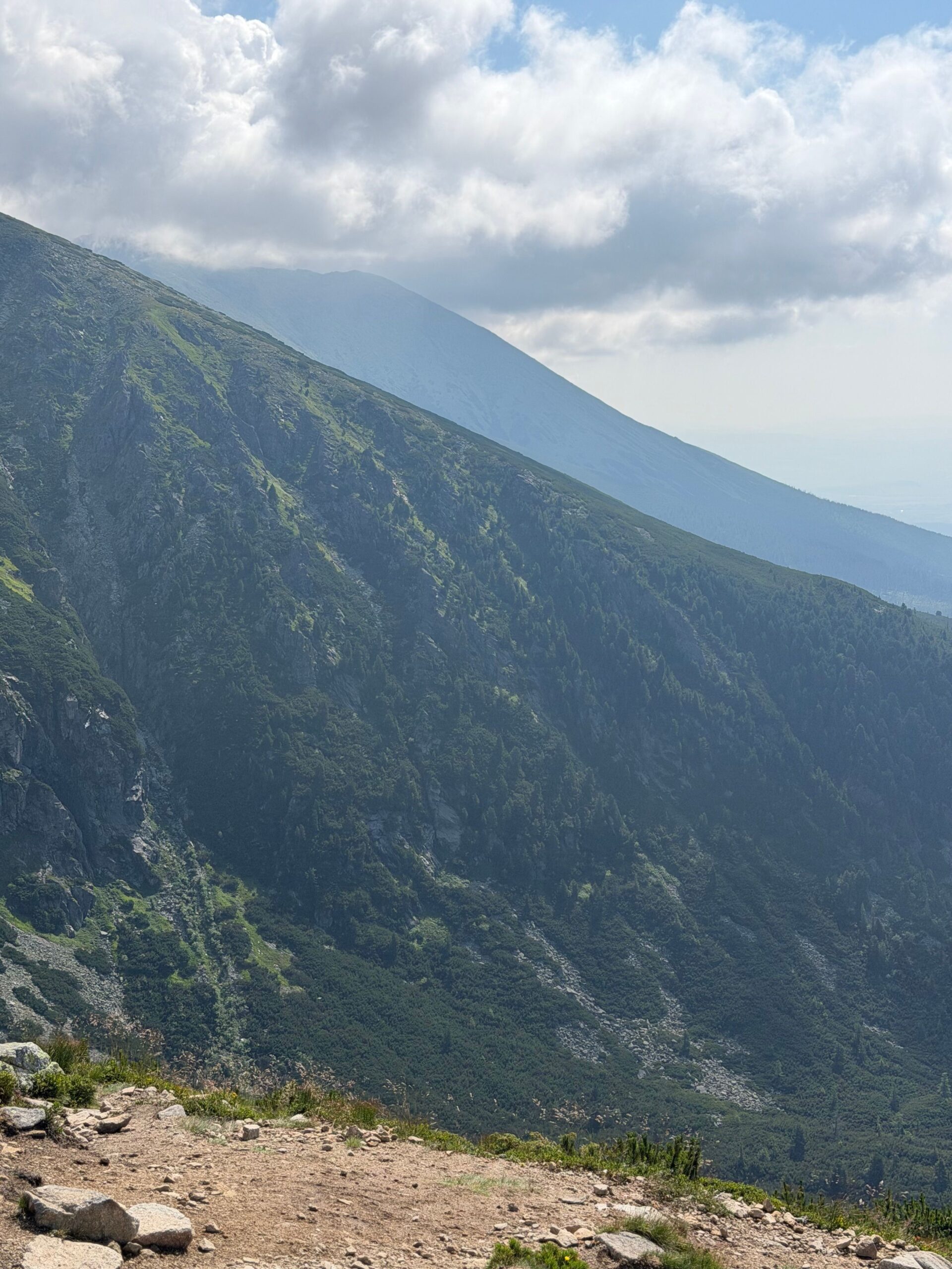 Zelené trávnaté svahy hôr pod jasnou oblohou v lete
