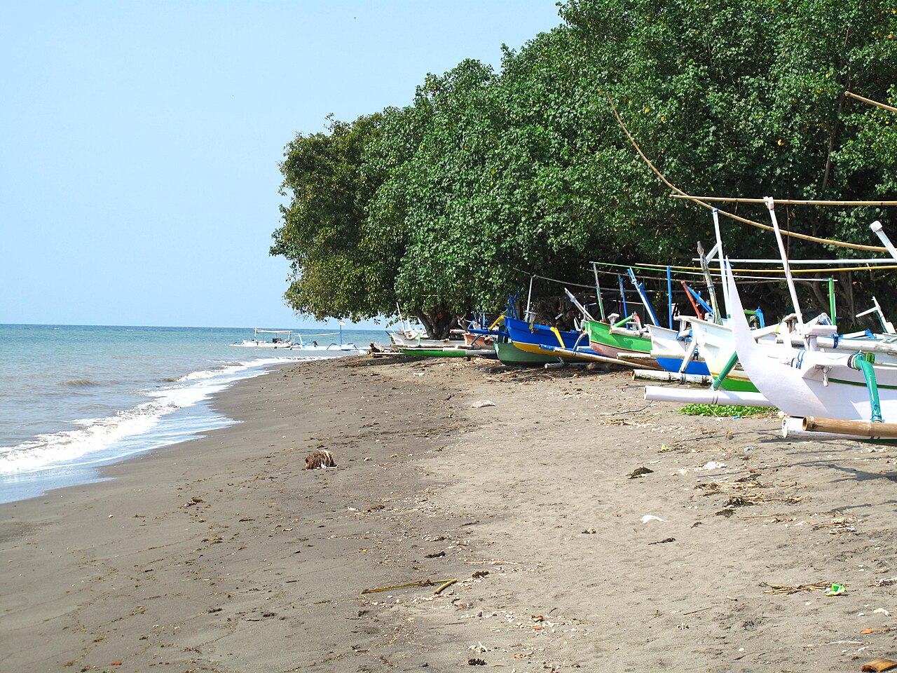 Tradycyjne łodzie jukung na spokojnej plaży w Lovinie