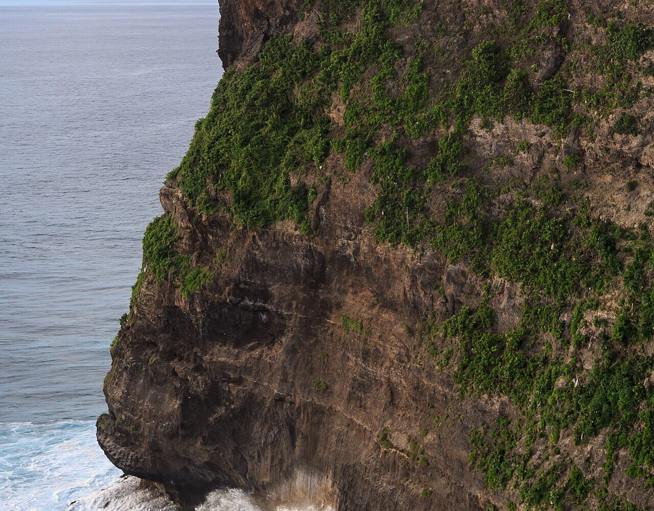 Chrám Pura Luhur Uluwatu na hraně útesu nad oceánem, dole se tříští vlny