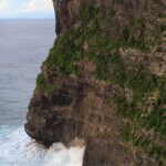 Chrám Pura Luhur Uluwatu na hraně útesu nad oceánem, dole se tříští vlny