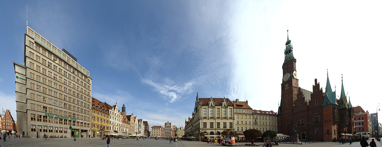 Vratislavský Rynek s gotickou radnicí a měšťanskými domy pod modrou oblohou