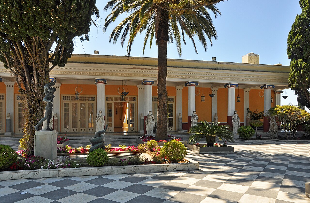 Terasa paláce Achilleion s mramorovou dlažbou, sochami a palmami