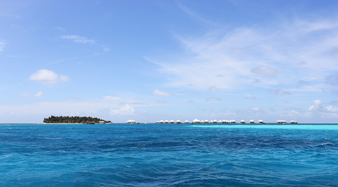 Resortní ostrov Thudufushi v maledivském atolu Ari s řadou vil nad vodou vybíhající do laguny