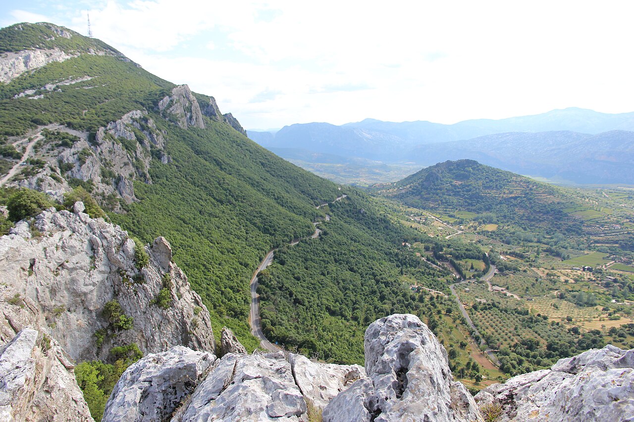 Silnice SS 125 Orientale Sarda se vine zeleným svahem nad údolím u Dorgali