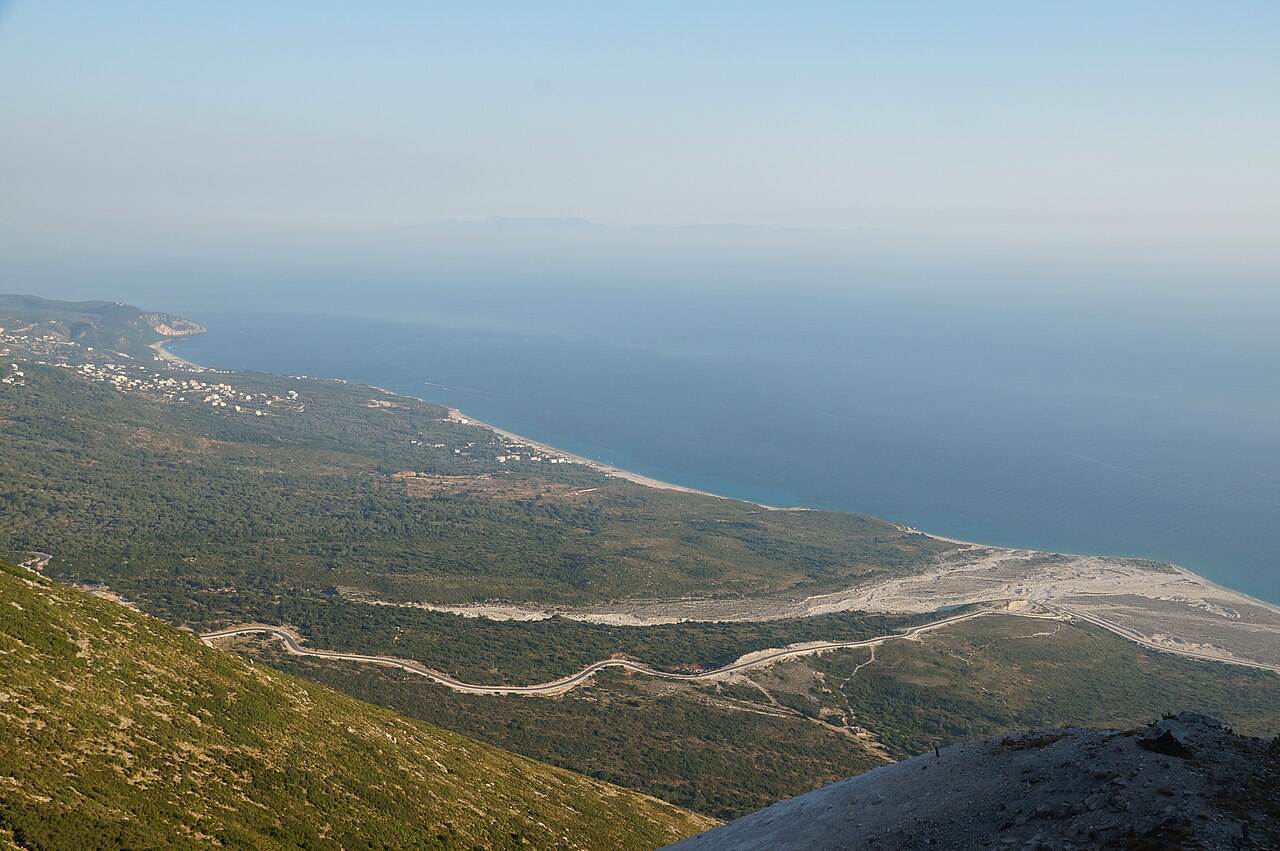 View from the Llogara Pass of the road winding down in hairpins to the coast with Palasa and Drymades beaches