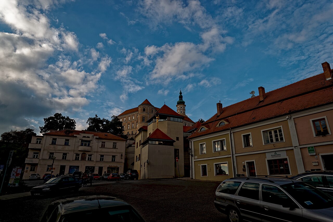 Zaparkovaná auta v ulici Svobody v Mikulově, nad domy se tyčí zámek