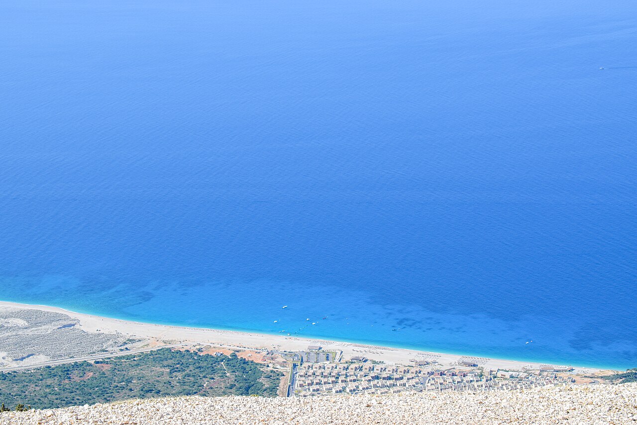 The long beach at Palasa with a seafront hotel complex, photographed from above on the Llogara Pass