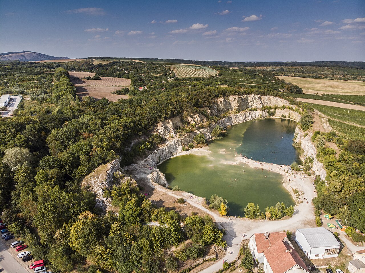Zatopený lom Janičův vrch v Mikulově z výšky, dvě zelené laguny se štěrkovými plážemi