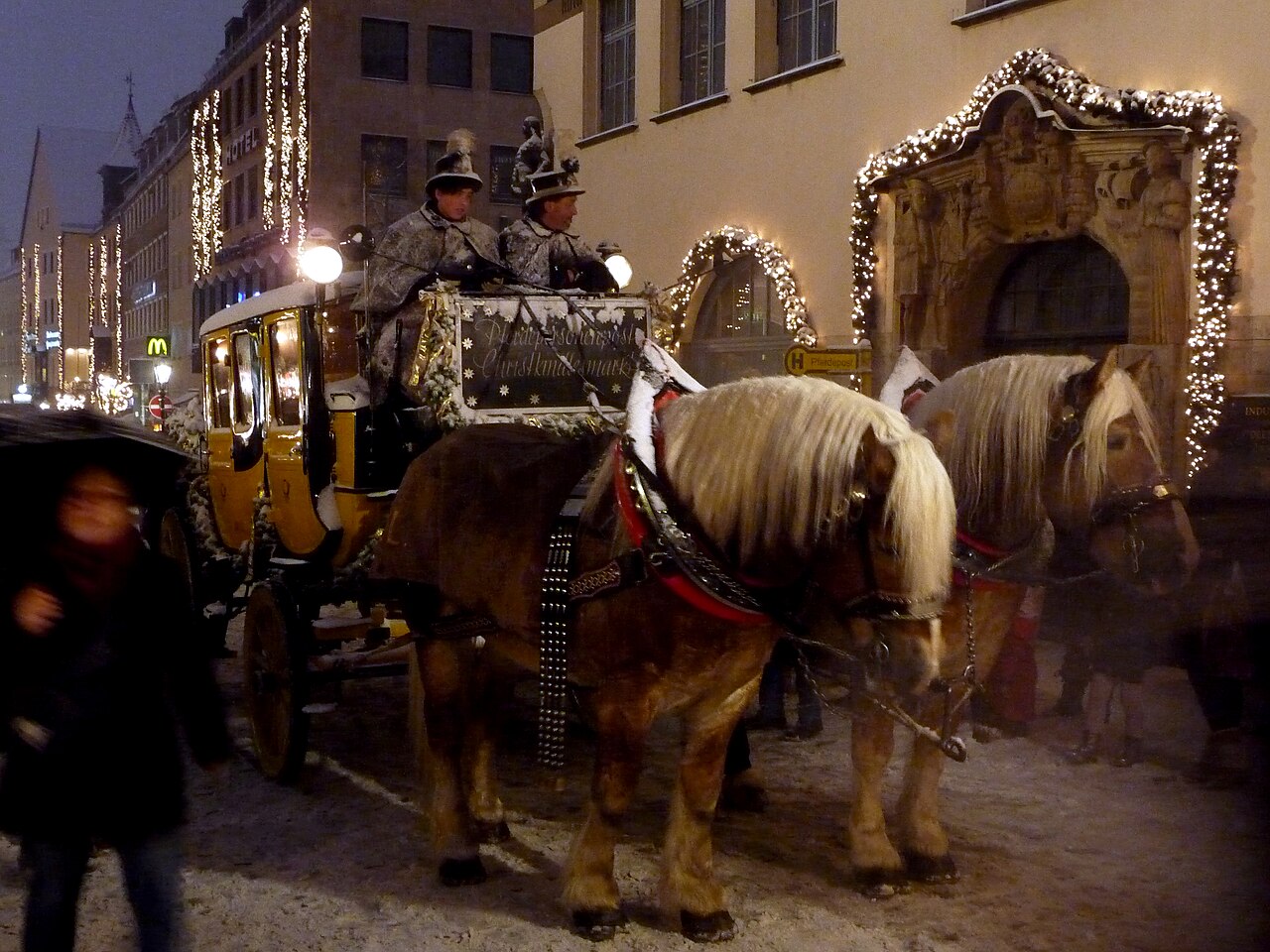 Poštovní dostavník s koňmi v zasněženém adventním Norimberku u Christkindlesmarktu