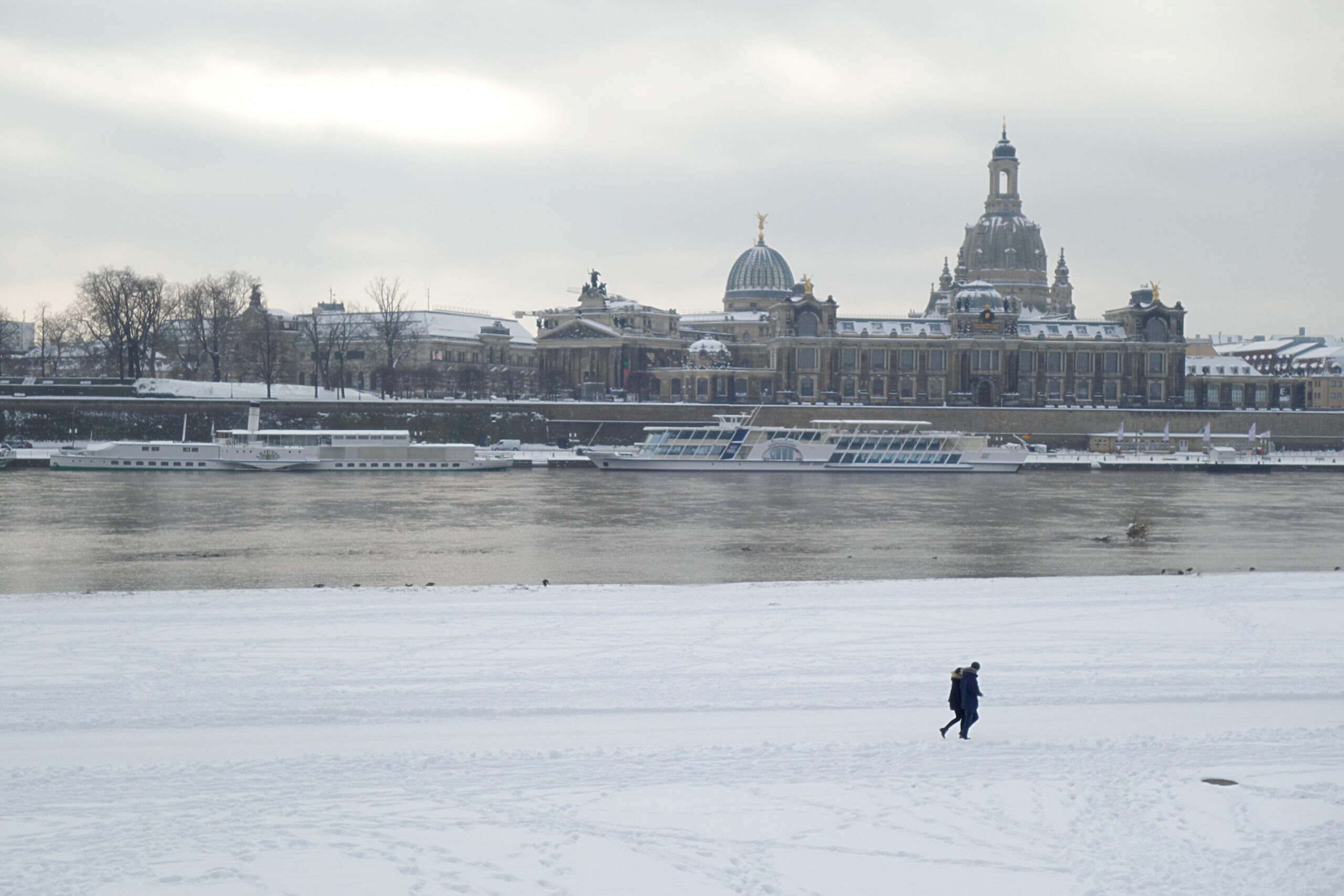 Snow-covered Elbe meadows in Dresden looking across the river to the Brühl Terrace, the Academy of Fine Arts and the Frauenkirche dome