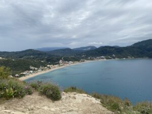 Vista desde una colina de una amplia bahía con una playa larga en la costa oeste de Corfú