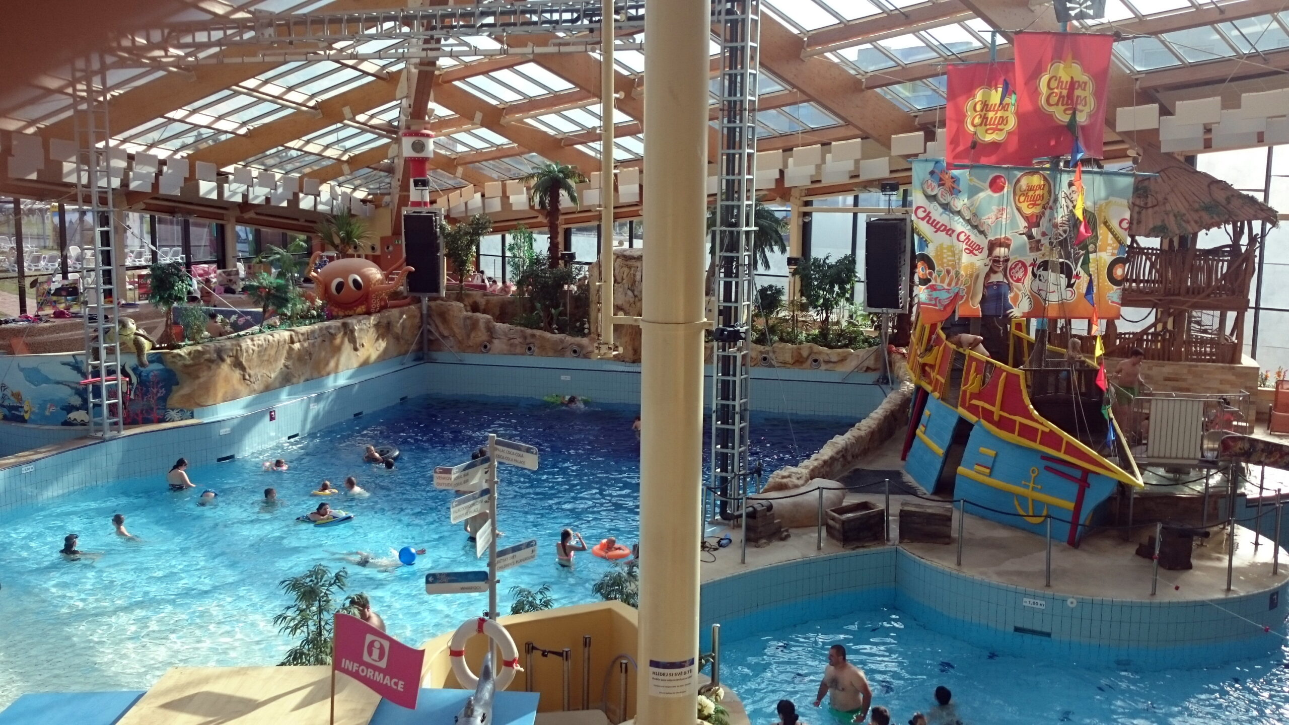 Vnitřní bazén aquaparku Aquapalace Praha v Čestlicích s pirátskou lodí, palmami a prosklenou střechou