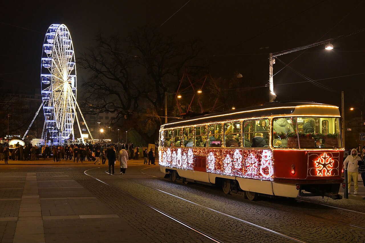 Vyzdobená vánoční tramvaj a rozsvícené vyhlídkové kolo na Moravském náměstí v Brně během vánočních trhů