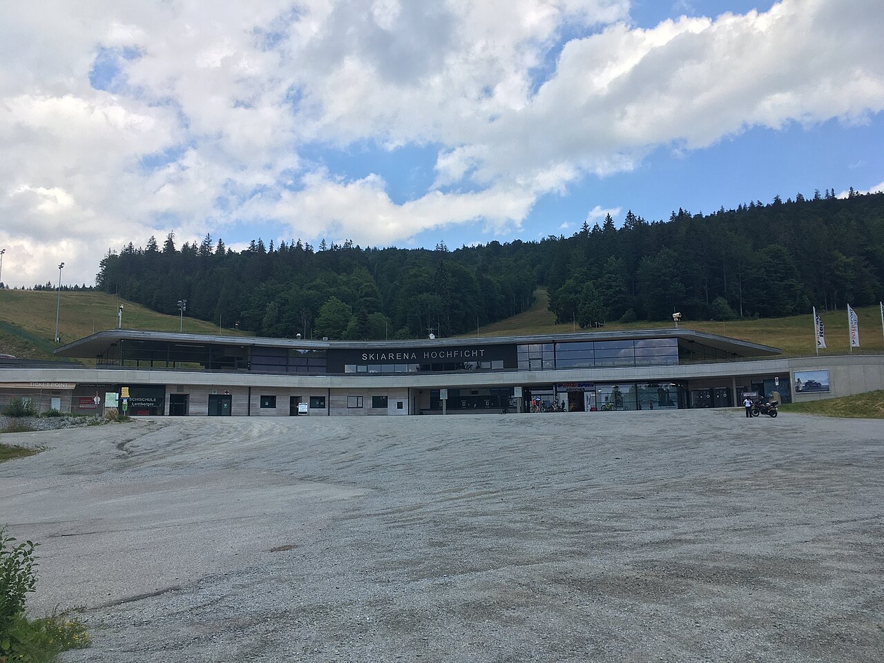 Budova Skiarena Hochficht s pokladnami, půjčovnou a restaurací, před ní velké parkoviště a za ní zalesněný svah se sjezdovkou